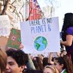 person holding there is no planet b poster