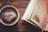 A steaming cup of coffee placed next to a notebook and pen, suggesting a moment of reflection.