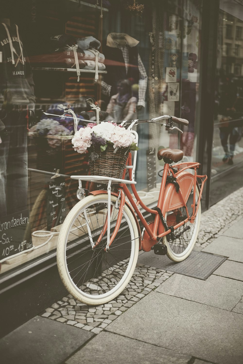 red step through bicycle parked on glass wall