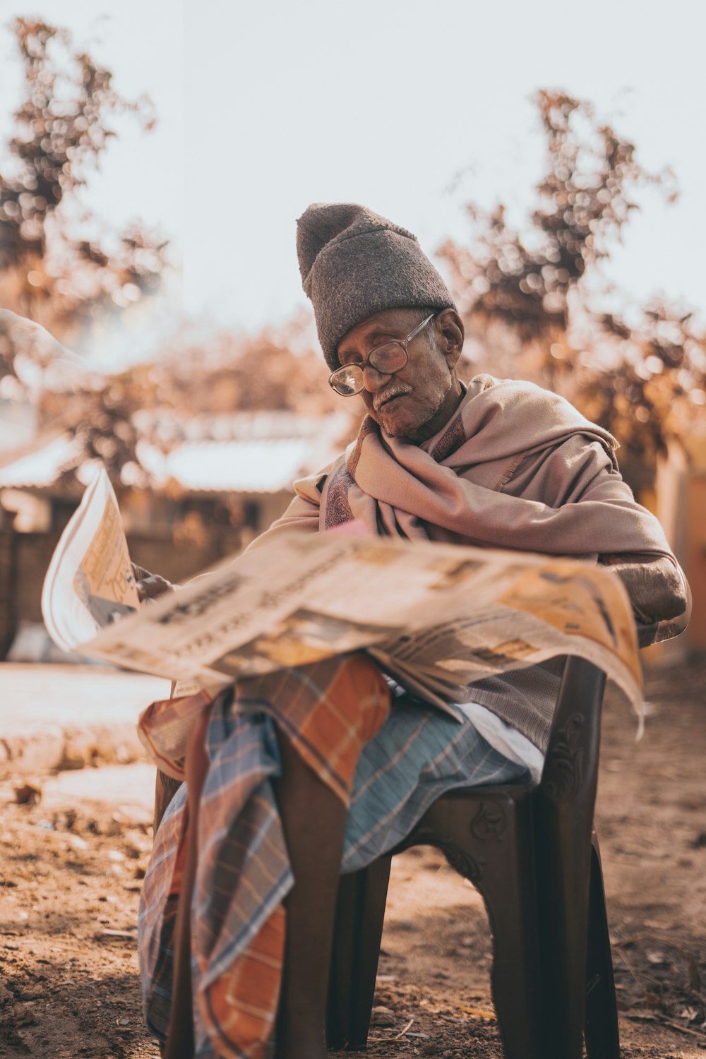 shallow focus photo of man reading newspaper