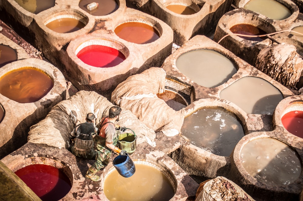 man holding two buckets near the paint container lot