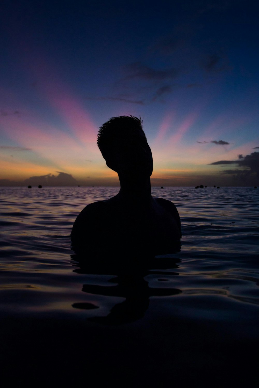 person in body of water during golden hour