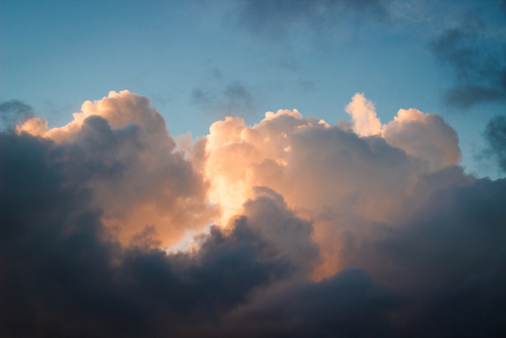 a plane flying through a cloud filled sky