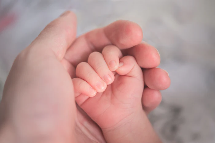 Close up of a baby's hand exploring a soft texture