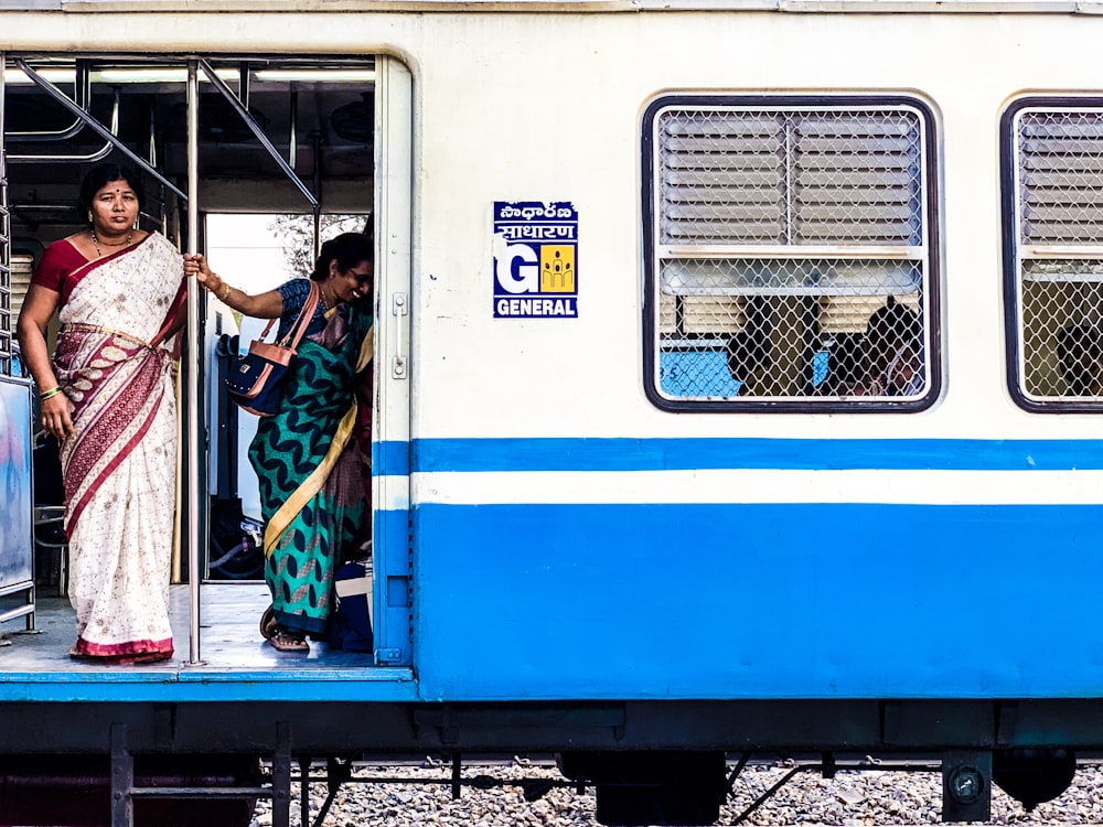 woman standing inside white and blue train