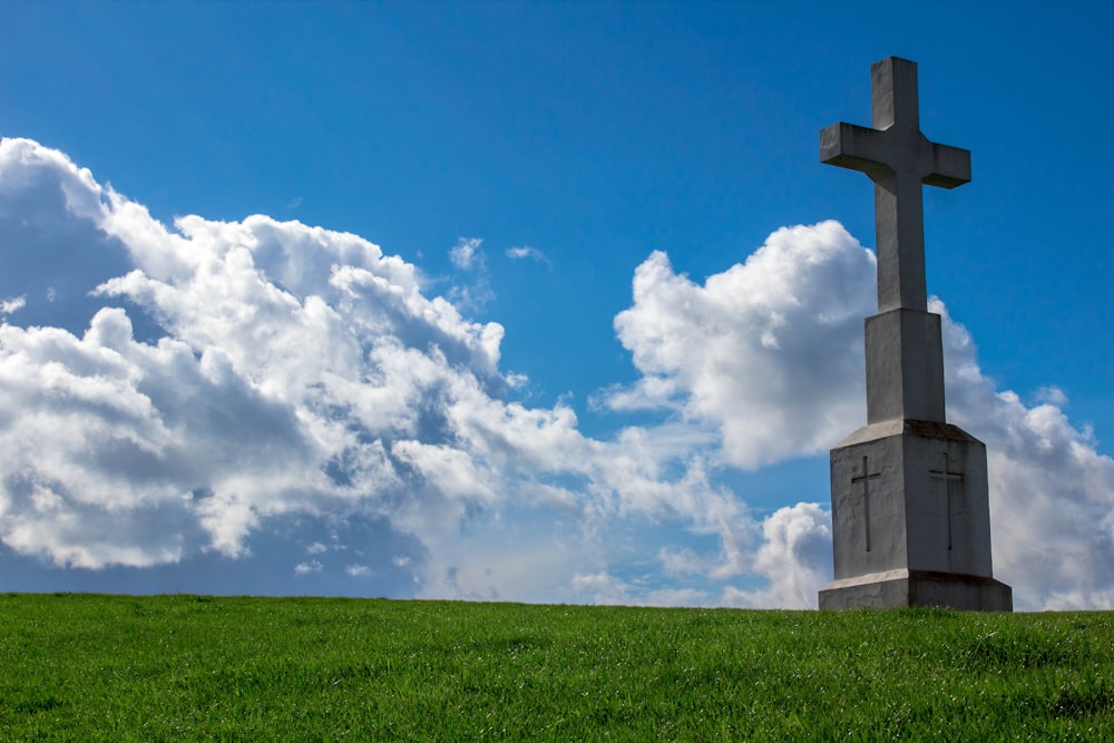 gray cross statue on grass