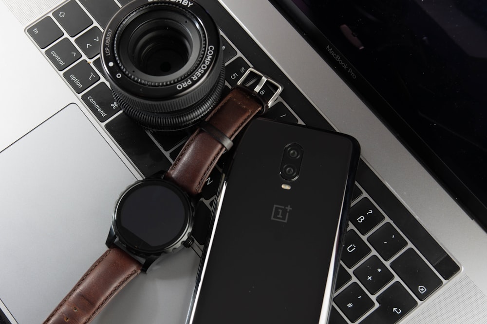 smartwatch noire ronde à côté du smartphone Android