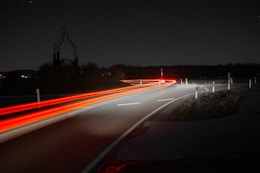 time-lapse photography of passing vehicles on road
