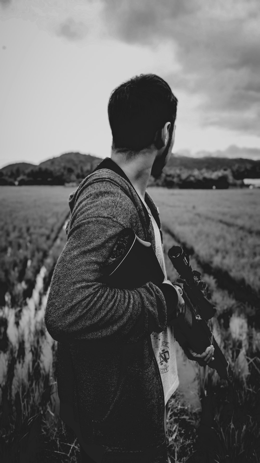 grayscale photo of man holding rifle