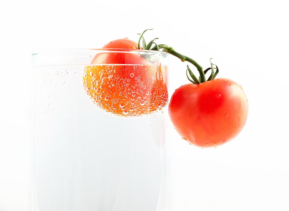 tomatoes on clear drinking glass