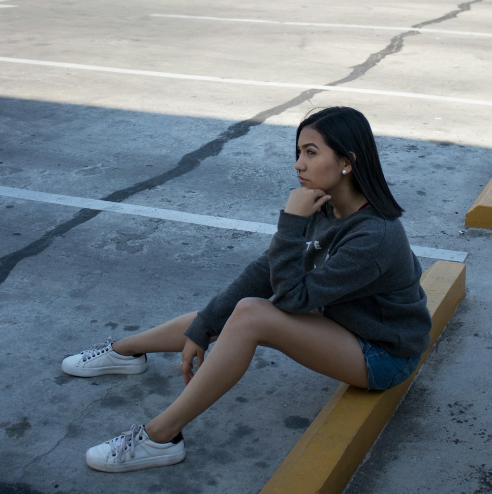 woman sitting on yellow concrete hump