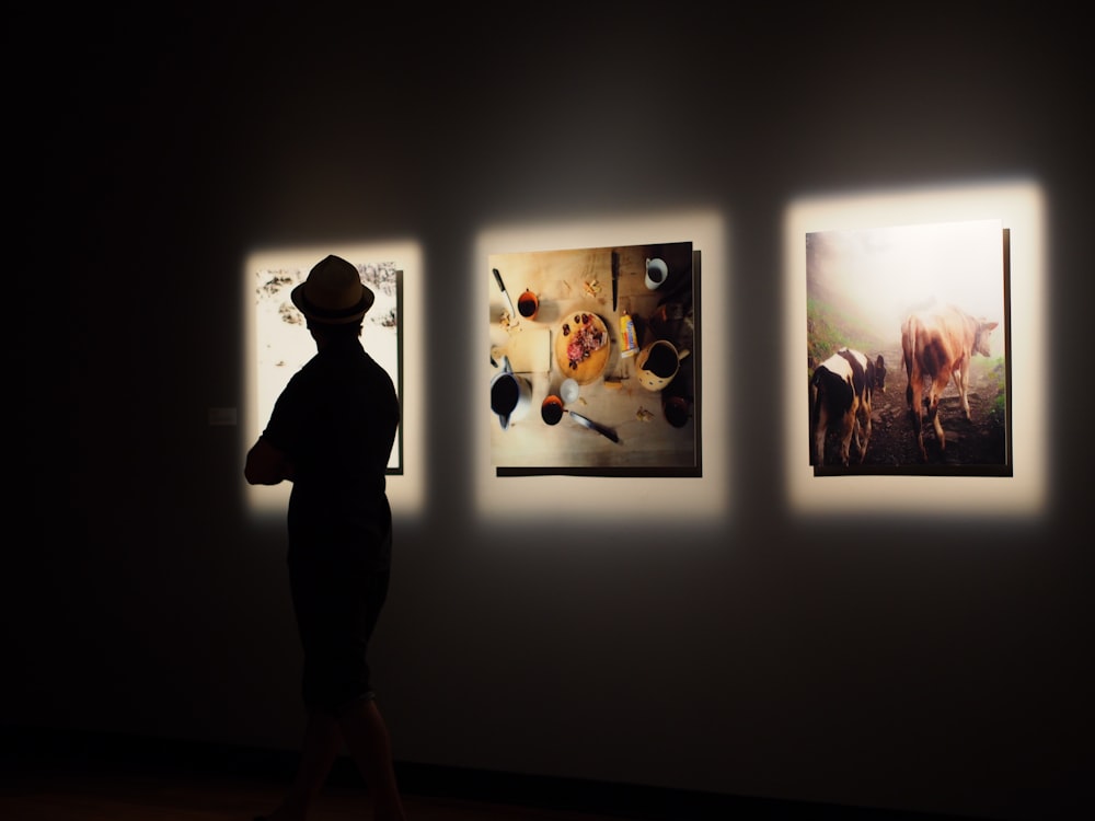 silhouette photo of man in front of painting