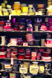 Hands selecting decorative ribbons and small craft accessories.