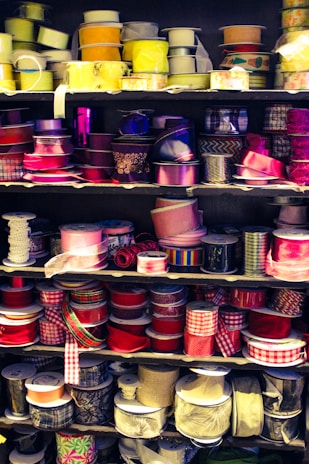 Display of colorful ribbons and trims hanging in a store aisle.