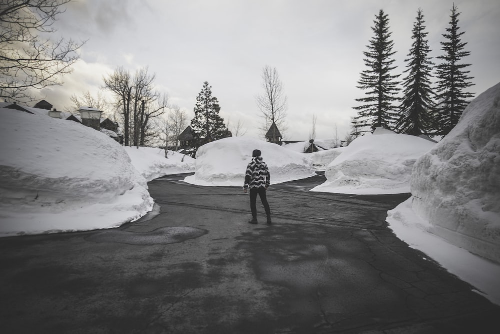 Photographie en niveaux de gris d’un homme entouré de neige