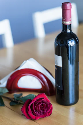 An elegant table setting with a Mother's Day card and a glass of red wine, shot from above with a unique polygonal photo border