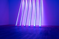 Pods lined up with glowing multiverse-inspired designs under purple and green lighting.