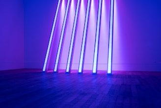 Pods lined up with glowing multiverse-inspired designs under purple and green lighting.