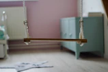 Bright and joyful kids' room with asymmetric shelves and a hanging swing.
