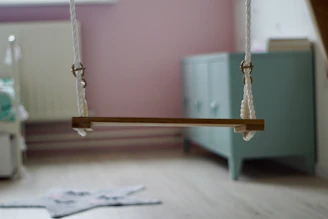 Child gently swinging on a certified sensory swing in a calm, softly lit therapy space.