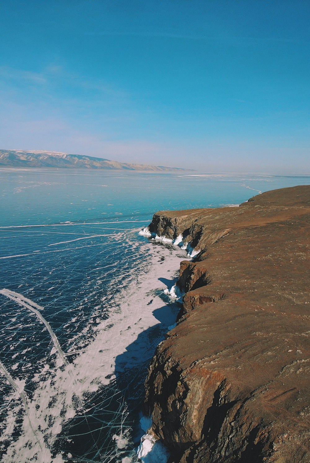 Fotografía aérea de un acantilado cerca del océano durante el día