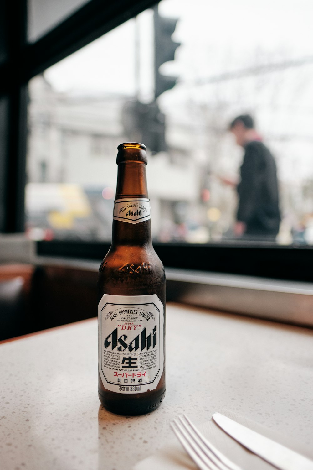 Asahi glass bottle on top of table