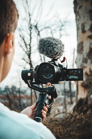 person holding DSLR camera during daytime