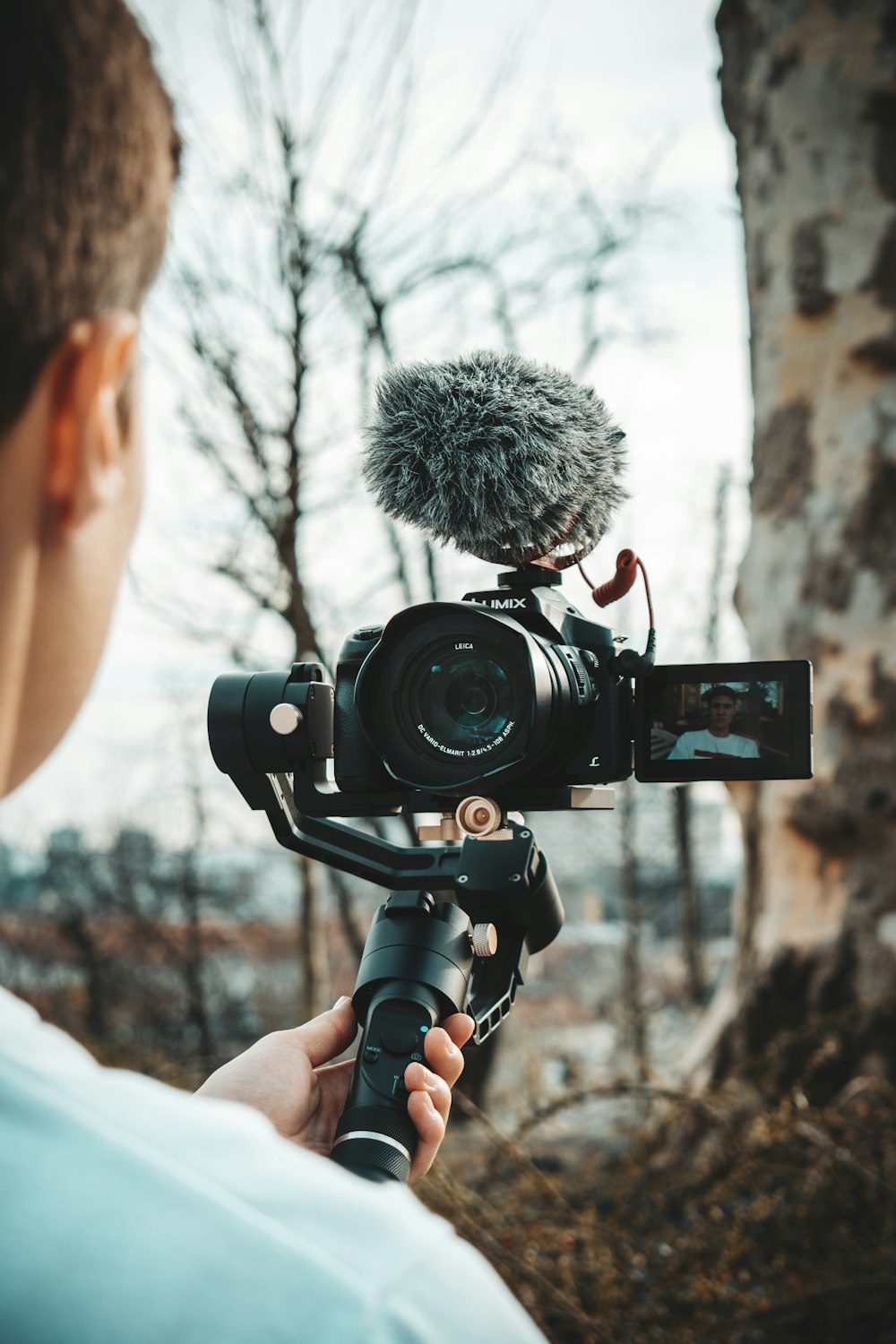 person holding DSLR camera during daytime