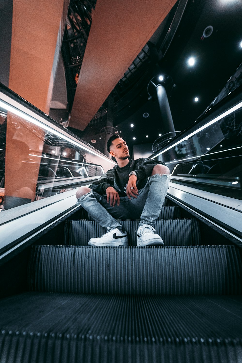 man sitting on escalator