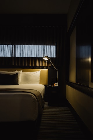 gray table lamp beside bed