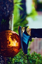 person stepping on bronze-colored ball