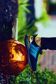 person stepping on bronze-colored ball