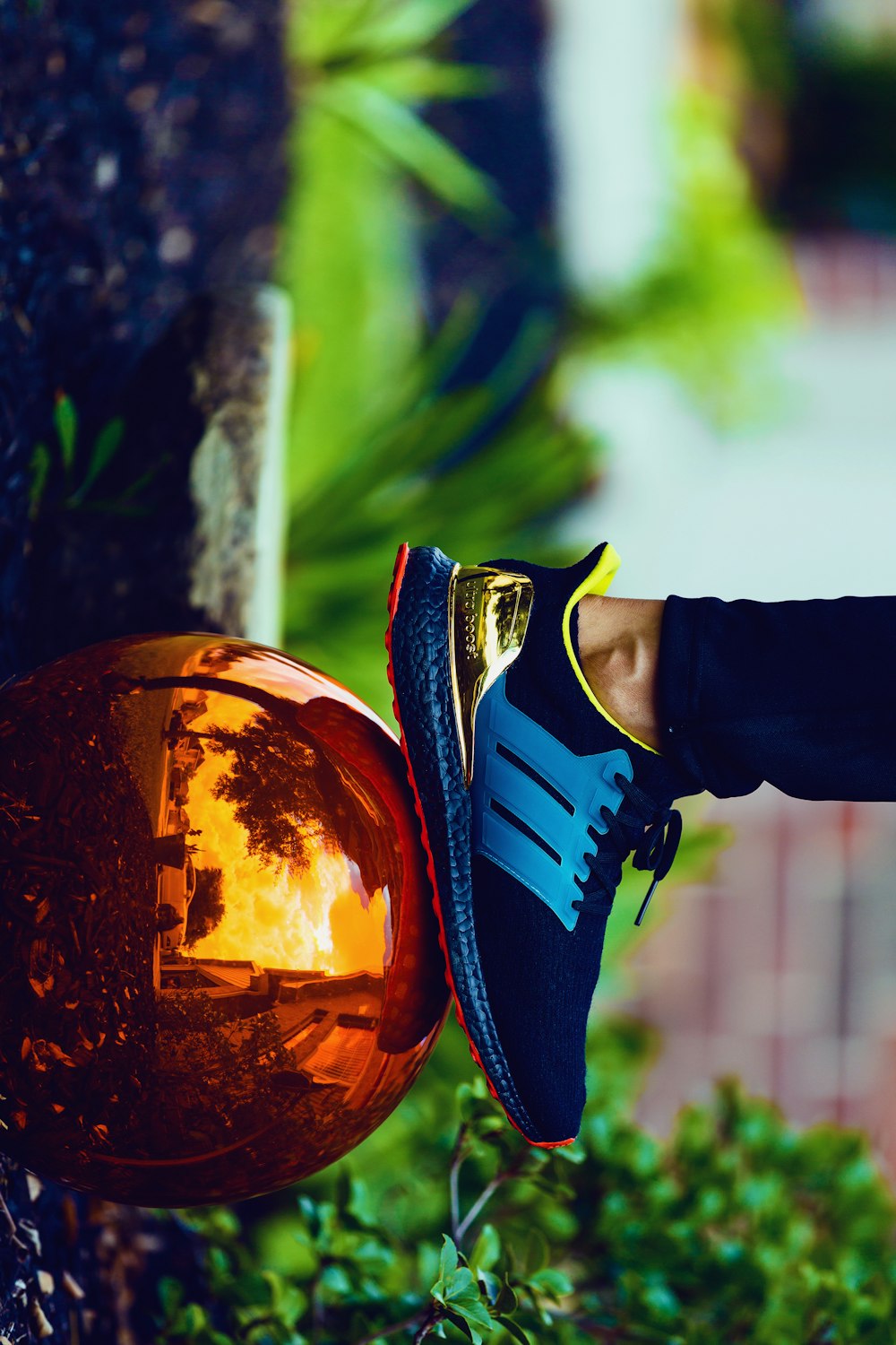 person stepping on bronze-colored ball