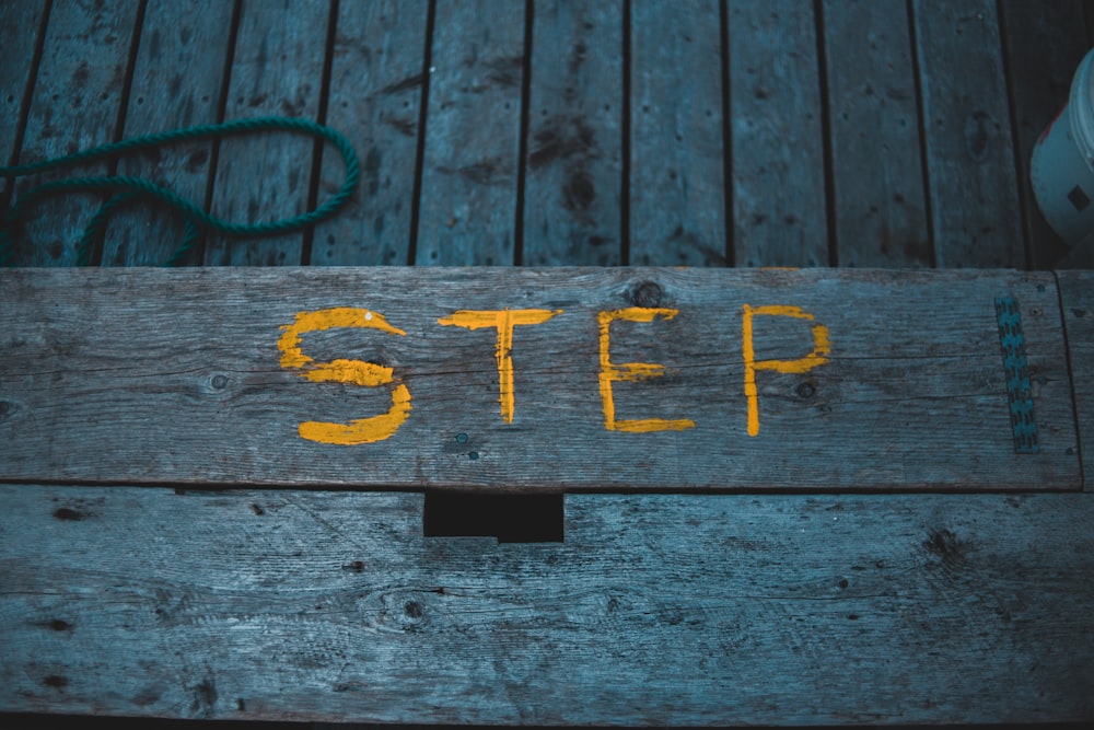 a wooden step with a yellow step painted on it