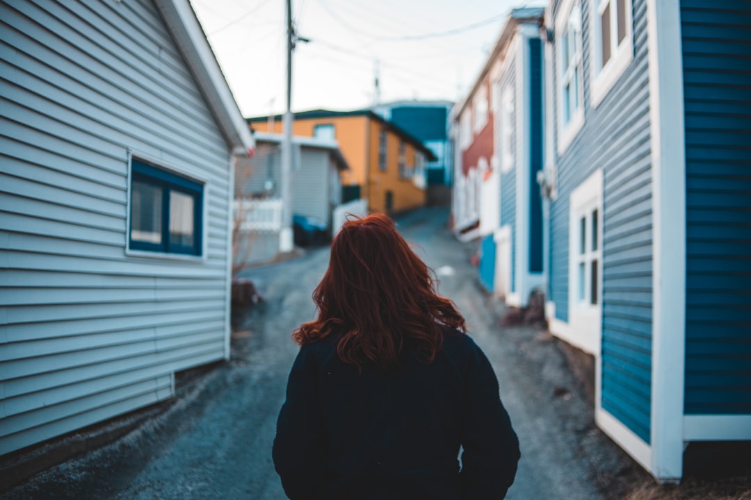 woman standing between houses