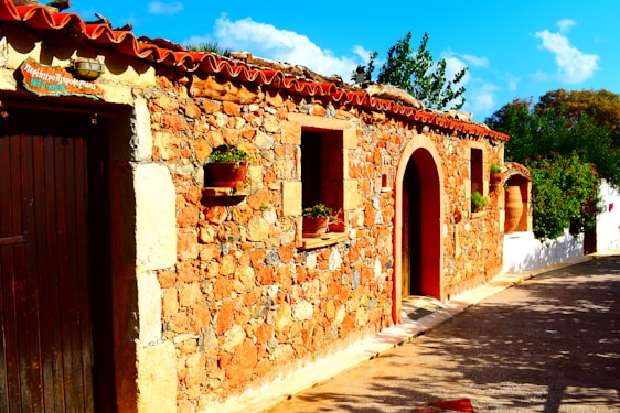 A warm, sunlit Catalan farmhouse surrounded by greenery, inviting a sense of community and shared living.