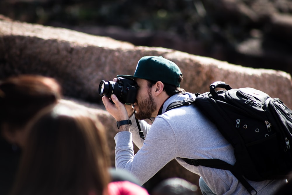 man taking photo beside rock formation