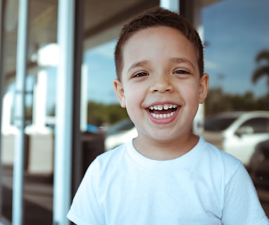 smiling boy wearing white crew-neck t-shirt during daytime