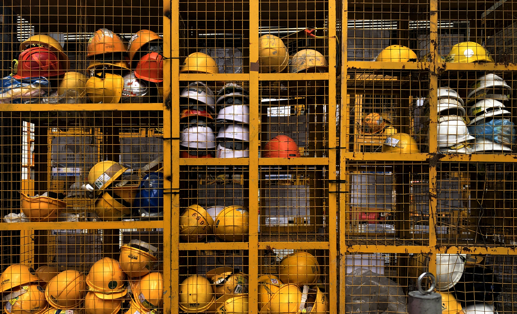 A rack of yellow industrial safety helmets ready for distribution
