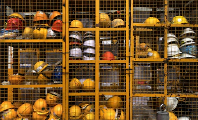 a rack filled with lots of yellow hard hats