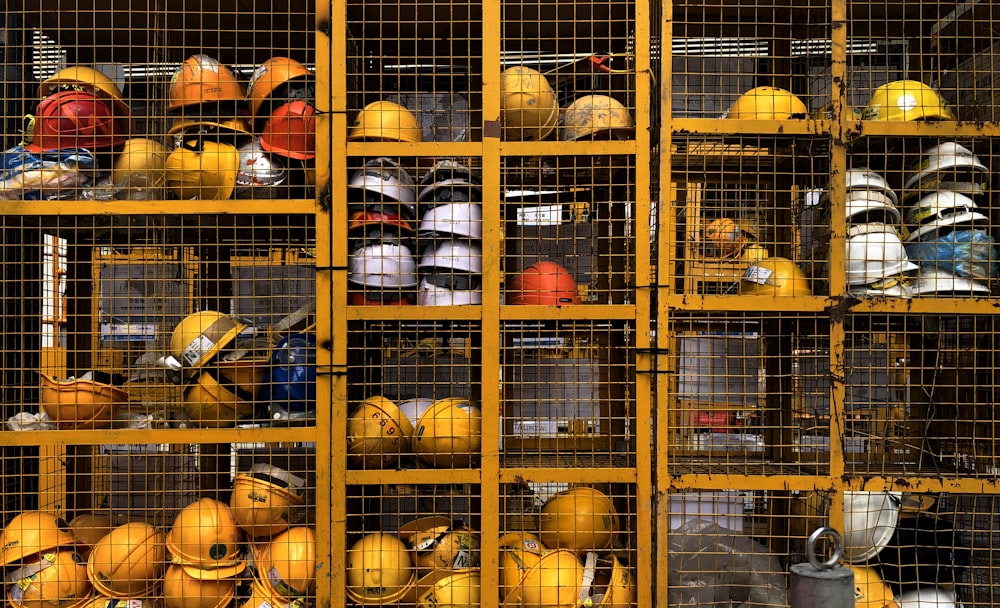 a rack filled with lots of yellow hard hats