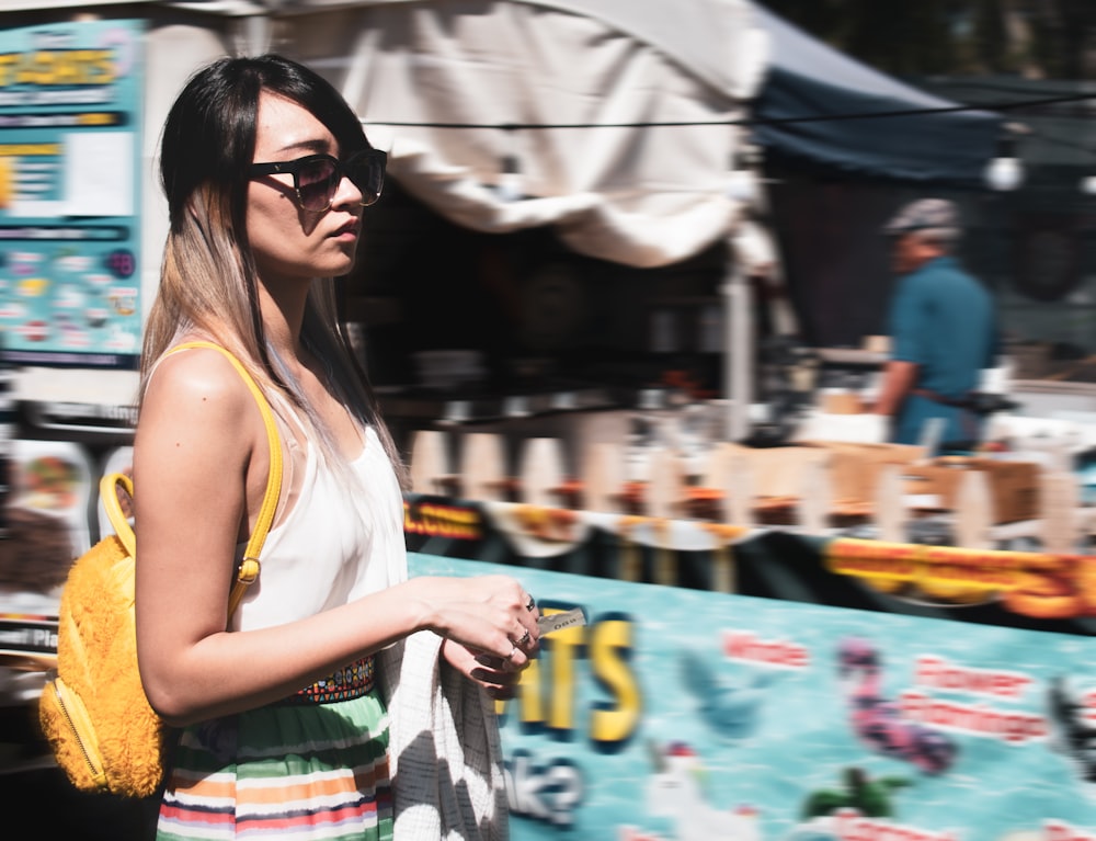 woman wearing black sunglasses passing stall