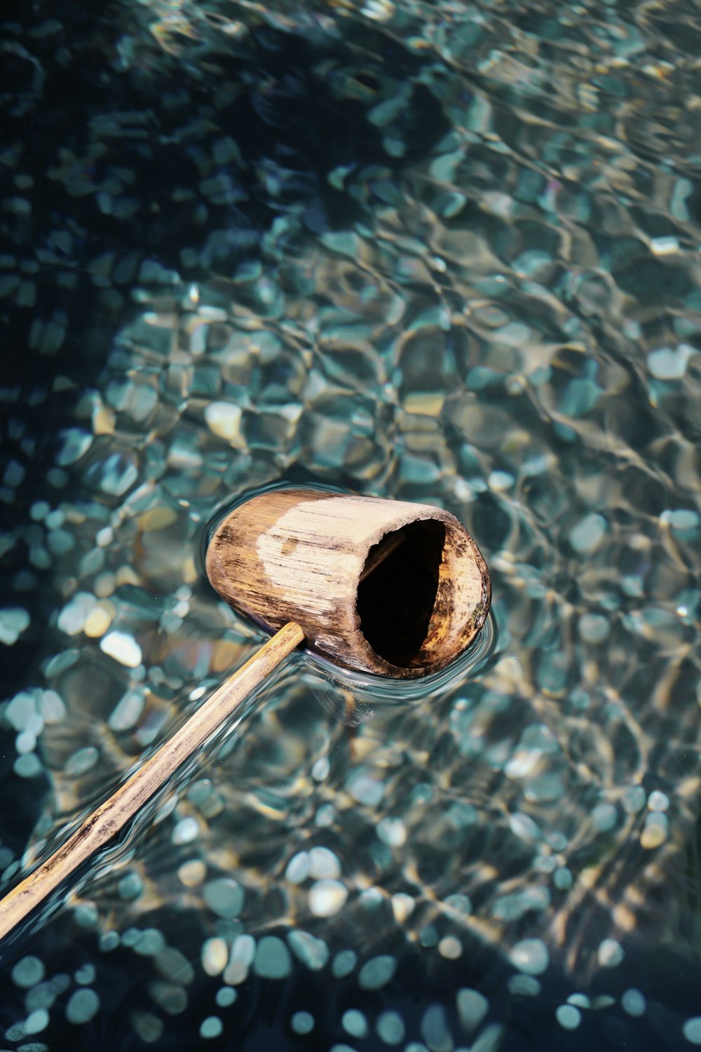 a wooden oar floating on top of a body of water