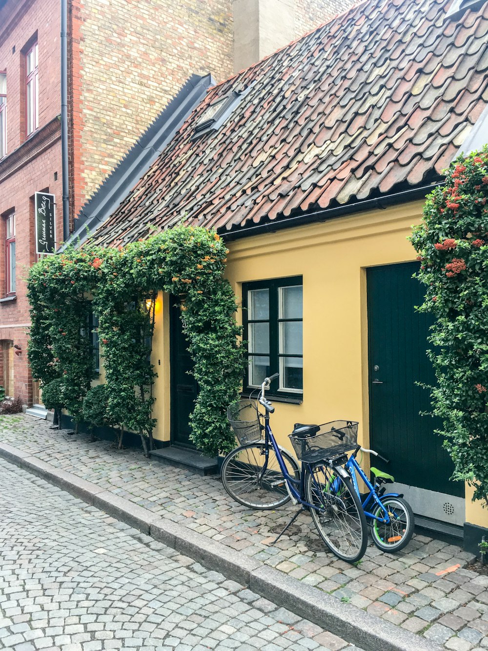 Blaues Cruiser-Fahrrad neben gelb-braunem Haus geparkt