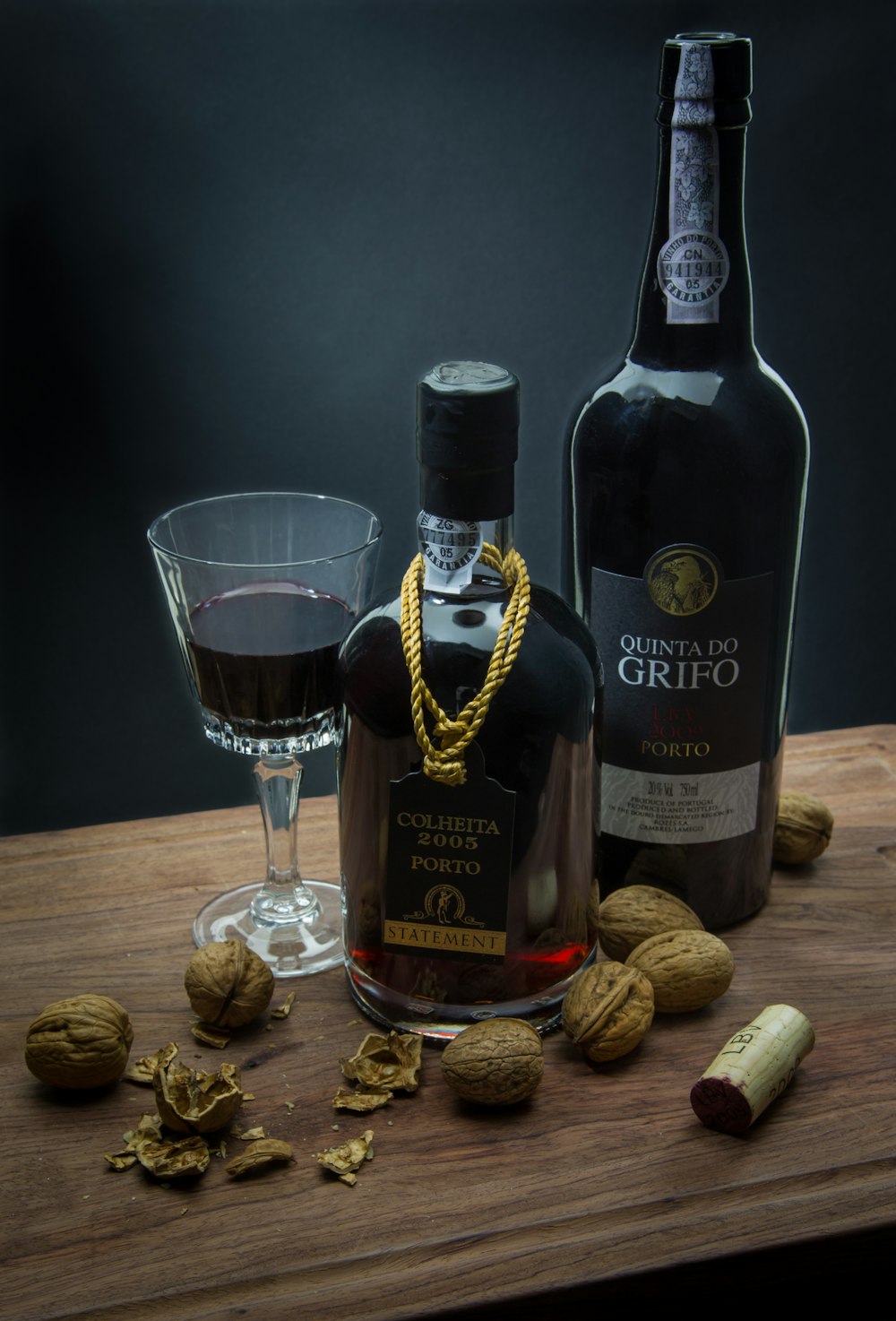 two liquor bottle beside wine glass on brown table