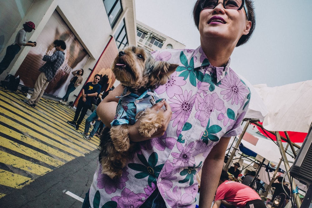 woman walking whiled holding puppy