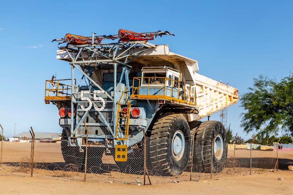 blue and white harvester at field during daytime