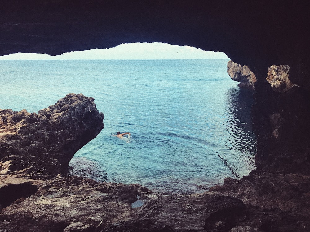 person swimming inside cave