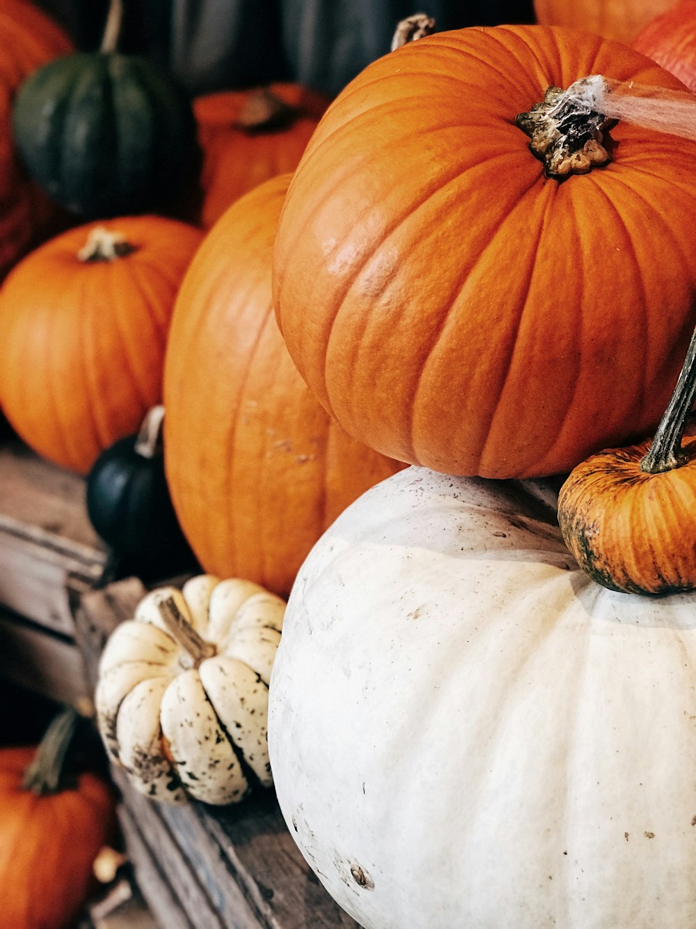 a pile of pumpkins sitting on top of a wooden table