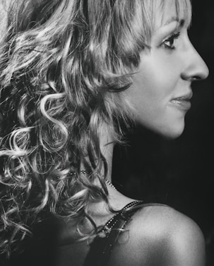 Black and white photo of a client with sleek, textured hair styled in a classic 90's studio shoot aesthetic.